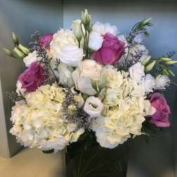 Bouquet of white hydrangeas and pink roses in a black vase