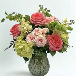 Pink roses and green hydrangeas in a textured glass vase