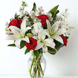 Red roses and white lilies in a clear glass vase