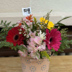 Mixed gerbera daisy bouquet in a pink floral tin