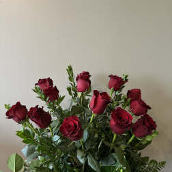 Tall arrangement of long-stemmed red roses with abundant foliage