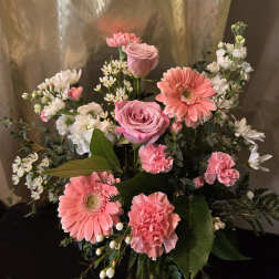 Pink roses and gerbera daisies with white filler flowers in a bouquet