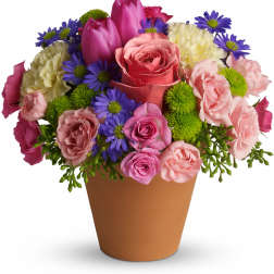 Mixed bouquet of pink, purple, and white flowers in a brown pot