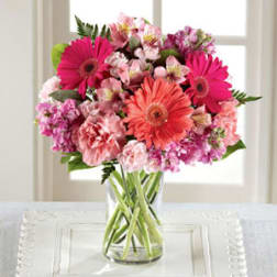 Pink and coral mixed bouquet in a clear glass vase