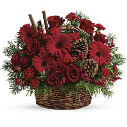 Red floral arrangement in a wicker basket with pinecones and evergreen accents