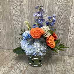 Blue hydrangea and orange roses in a decorated container