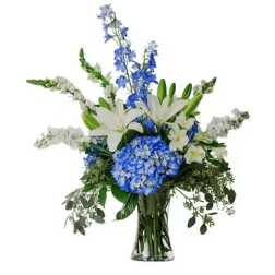 Blue and white floral arrangement in a clear glass vase