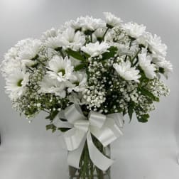 White daisy bouquet in a glass vase with a white ribbon