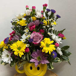 Mixed bouquet in a yellow smiley-face mug vase