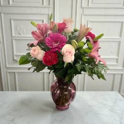 Pink and red mixed bouquet in a purple glass vase