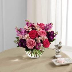 Pink and purple rose bouquet in a clear glass vase