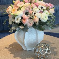 Pastel bouquet of roses and ranunculus in a white vase