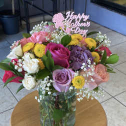 Mixed rose bouquet in a glass vase with a Happy Mothers Day sign