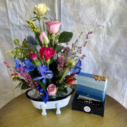 Mixed bouquet in a white vase with pink, blue, and yellow flowers