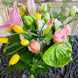 Mixed bouquet with pink and yellow tulips, pink ranunculus, and white blooms