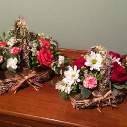 Two rustic floral baskets with red roses and white daisies