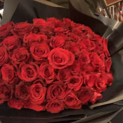Large bouquet of red roses wrapped in black paper