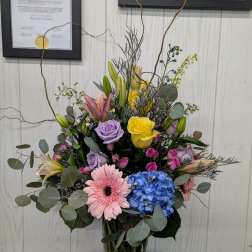 Mixed bouquet in a glass vase with roses, lilies, gerbera daisies, and hydrangea