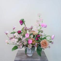 Pink and peach mixed flower arrangement in a white vase