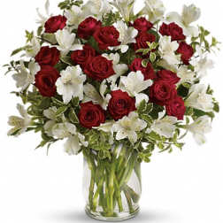 Red roses and white alstroemeria in a clear glass vase