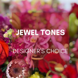 Blurred jewel-toned floral arrangement with the words "JEWEL TONES DESIGNER'S CHOICE"