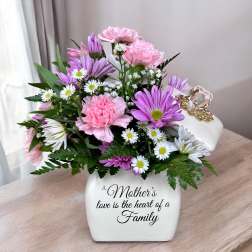 Pink and purple bouquet in a white vase with a Mother’s Day message