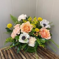 Peach roses and white anemones in a green vase