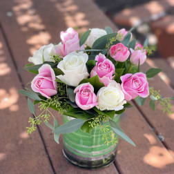 Pink and white roses arranged in a glass vase