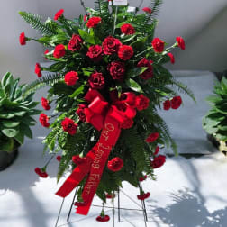 Standing red rose and carnation spray with a red ribbon