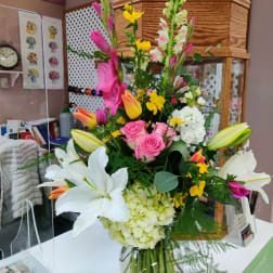 Tall mixed bouquet with lilies, roses, hydrangea, and snapdragons in a glass vase