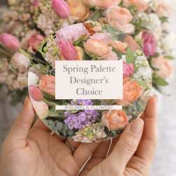Hands holding a round floral card with pastel spring flowers