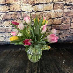 Tulip bouquet in a clear glass vase with pink, yellow, and white blooms.