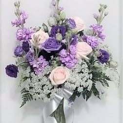 Lavender and pale pink bouquet in a glass vase with a silver ribbon