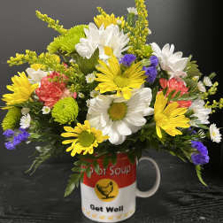 Mixed daisies and carnations arranged in a Get Well mug