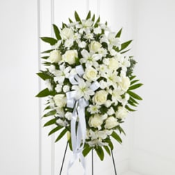 White floral standing spray with ribbon on an easel