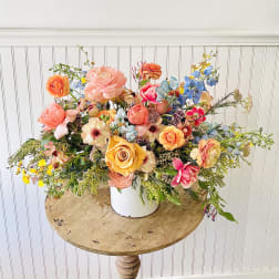 Colorful mixed flower arrangement in a white container
