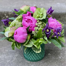 Pink and purple flower arrangement in a green dotted vase