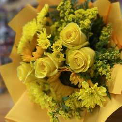 Yellow rose and chrysanthemum bouquet wrapped in yellow paper