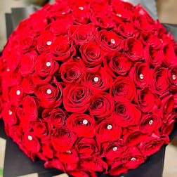Round bouquet of red roses wrapped in black paper