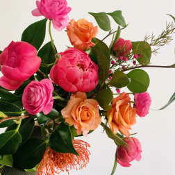 Bouquet of pink and orange roses with mixed greenery
