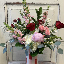 Mixed bouquet of pink and red roses in a striped vase