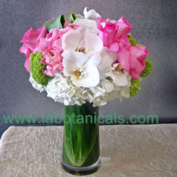 Pink and white bouquet in a tall green glass vase
