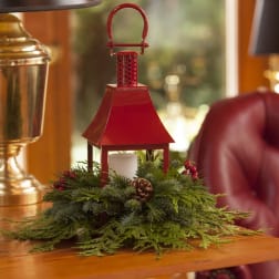 Red lantern centerpiece with evergreen and a candle
