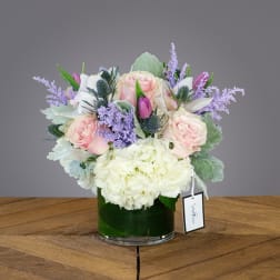 Pink roses and white hydrangeas in a glass vase with lavender accents