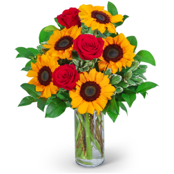 Sunflowers and red roses in a clear glass vase
