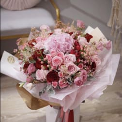 Pink and red rose bouquet wrapped in pale paper