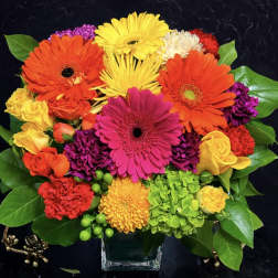 Colorful mixed bouquet in a clear square vase