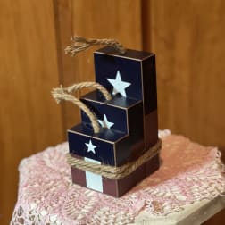 Stacked navy gift boxes tied with rope and star cutouts