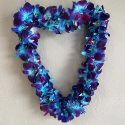 Heart-shaped floral wreath of blue and purple orchids on a wall