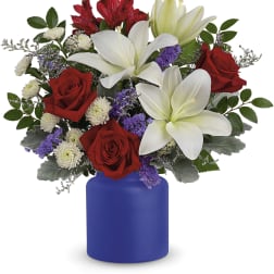 Bouquet of red roses and white lilies in a blue vase